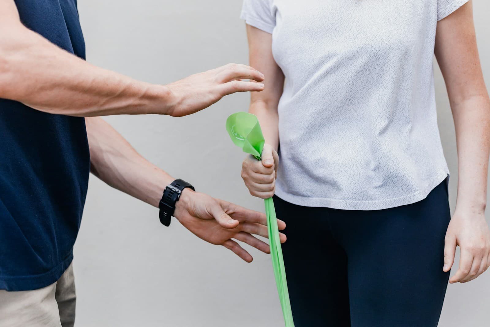 Fisioterapista che guida una persona con una fascia elastica verde